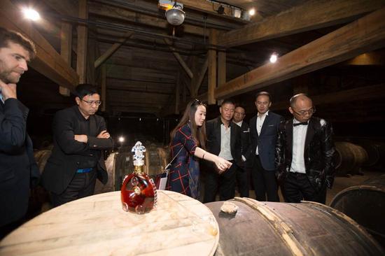 路易十三傳訊經(jīng)理史佳瓊（左三）向好友們介紹用于陳釀生命之水的專屬蒂爾肯橡木桶。它由樹齡達150年的利木贊橡木制成，是成就路易十三傳奇的獨特珍寶，除路易十三之外任何干邑都無此殊榮。